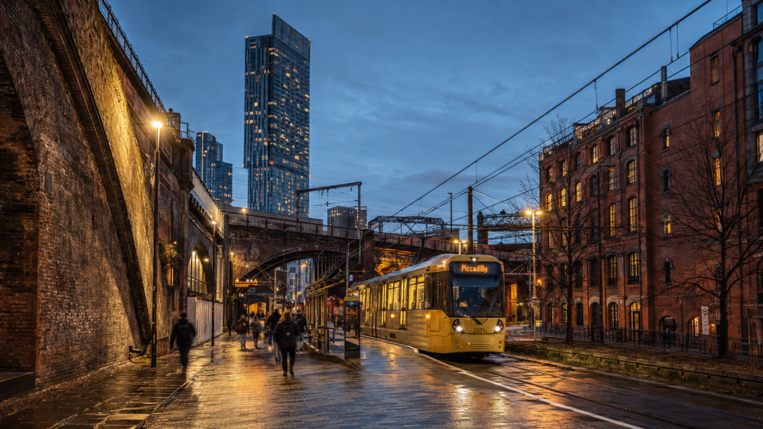 A tram at Deansgate at dusk with the Beetham Tower rising behind, in the Manchester neighbourhood Hostahome manages short-lets in.