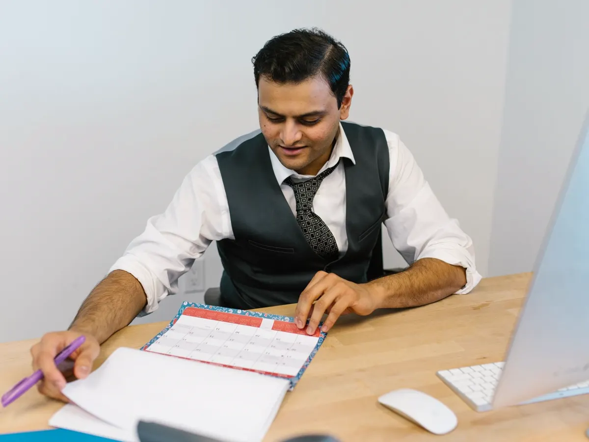 Someone checking a schedule against a calendar